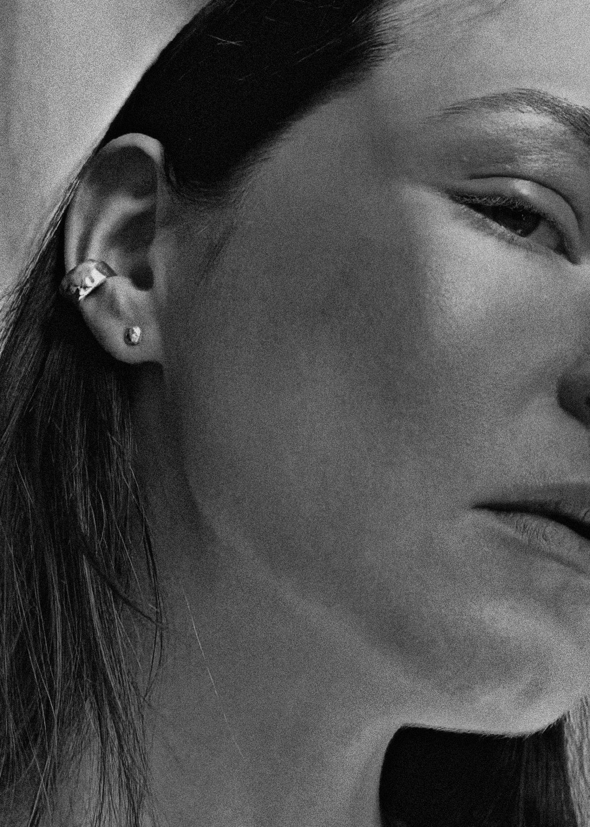 Close-up of a person wearing an earring with a neutral background